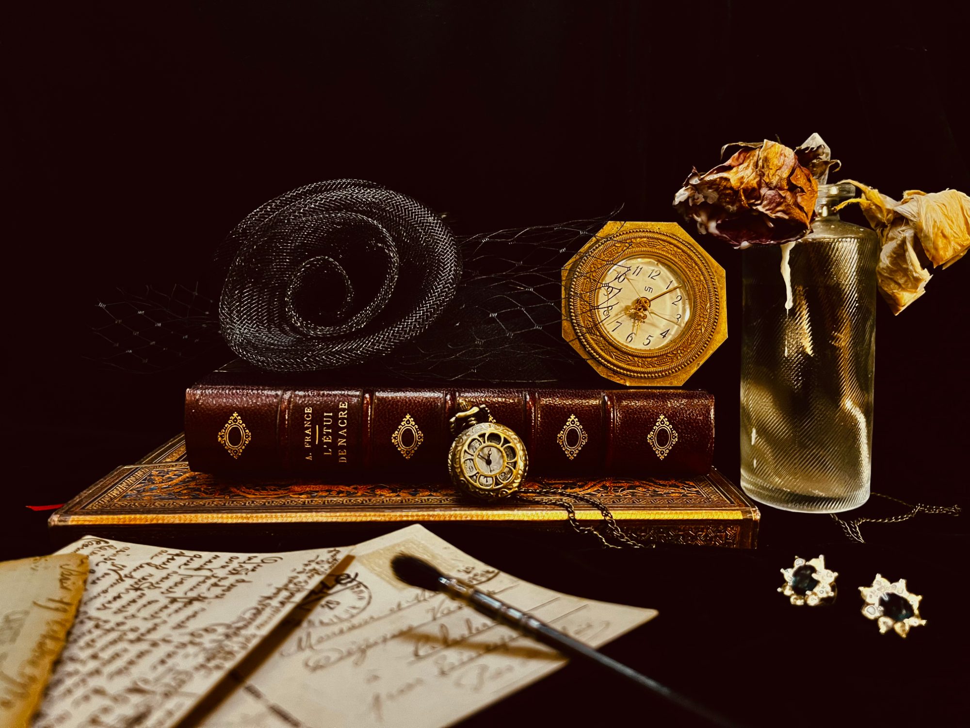 Leather-bound book, antique clocks, dried roses and handwritten postcards